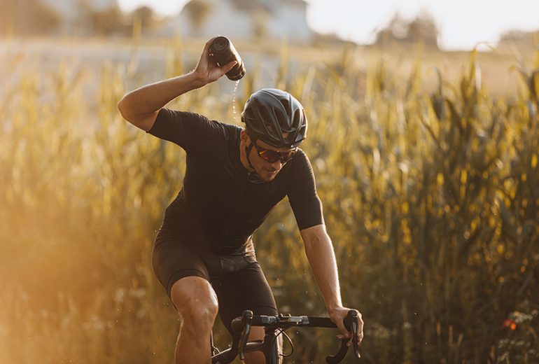 Uomo in bici che si rinfresca con la borraccia