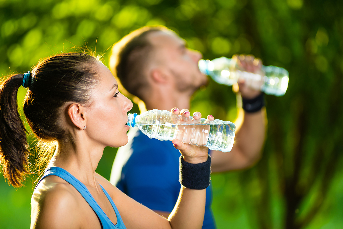 Donna e uomo sportivi che bevono acqua